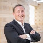 Vorstand Max Wörner im Porträt vor Wand aus nachhaltigem TRIQBRIQ-System