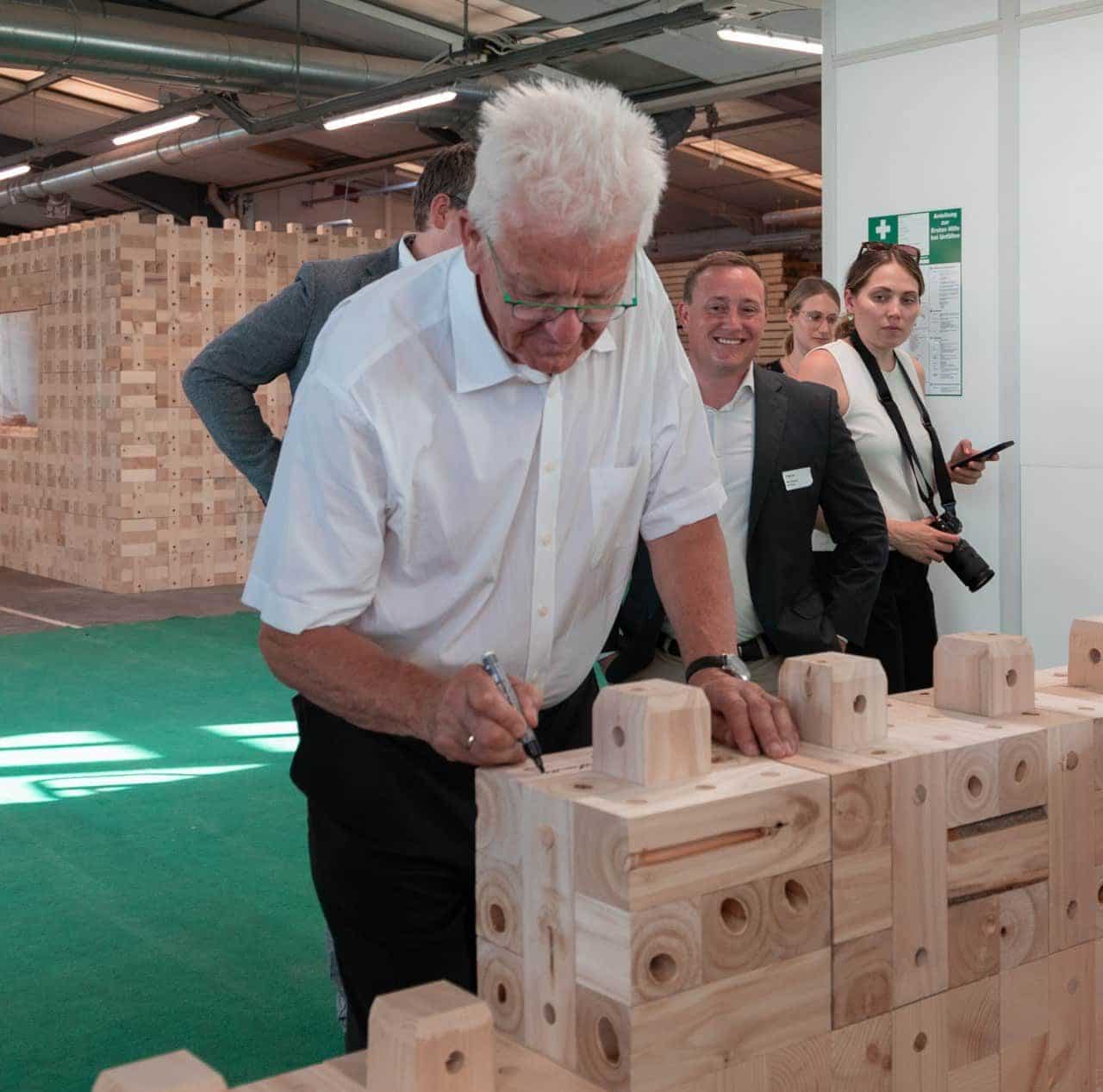 Nachhaltig bauen: Winfried Kretschmann zu Besuch im Holzmassivbau Stammwerk der TRIQBRIQ AG in Tübingen
