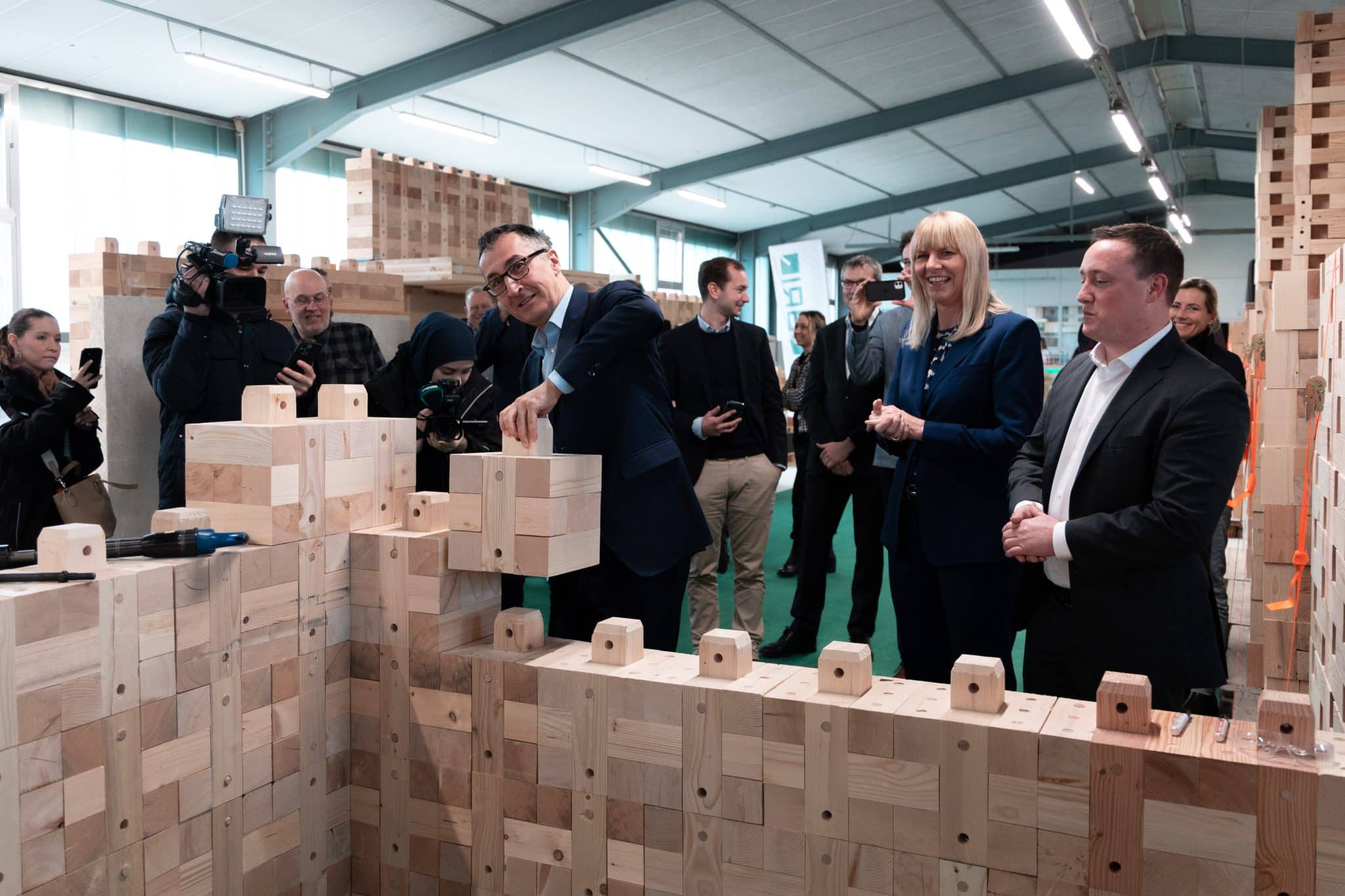 Bauminister Cem Özdemir platziert einen BRIQ im Holzbau Stammwerk in Tübingen