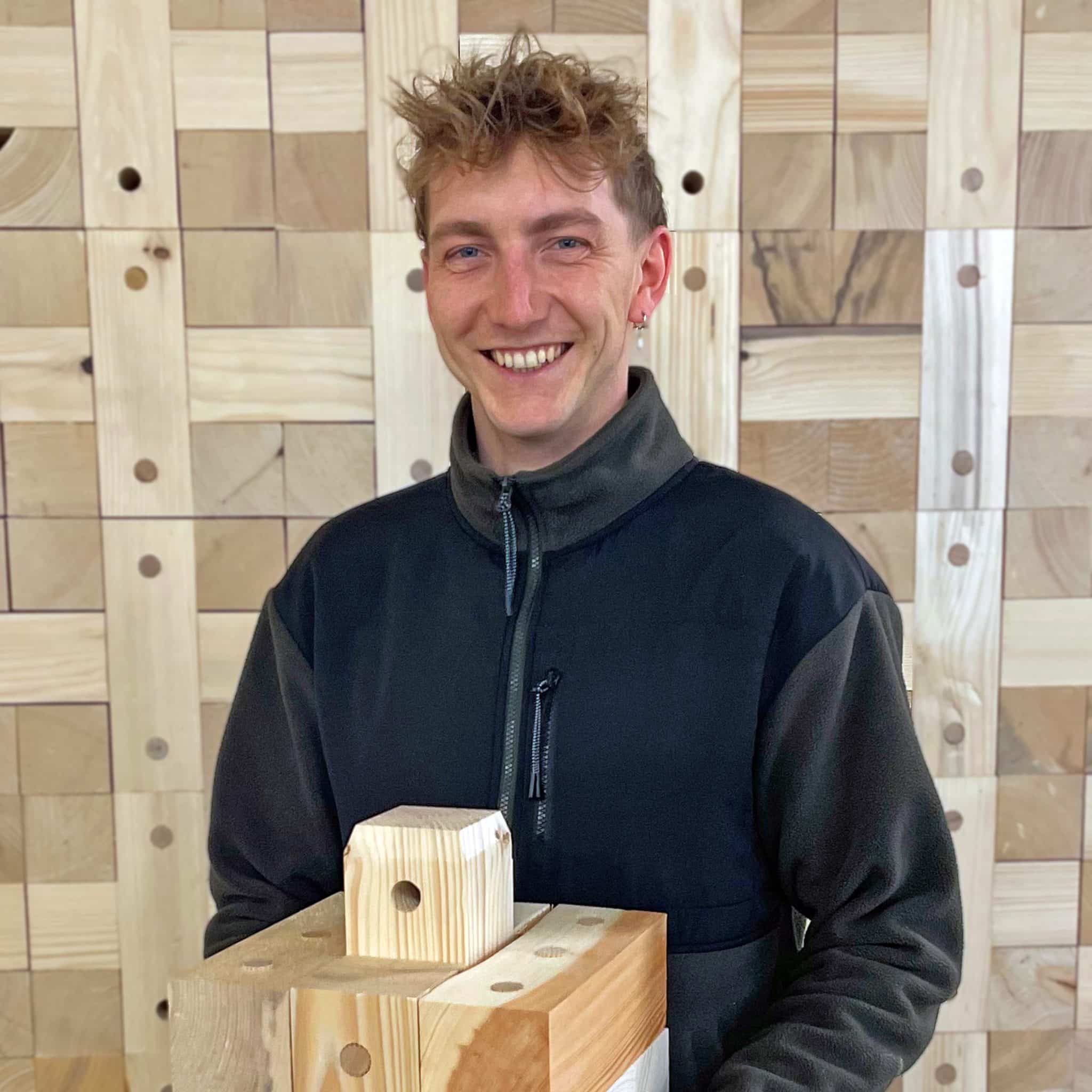 Werkstudent Yannik Nolle vor Holzbau bei Massivholzhaus Hersteller TRIQBRIQ in Tübingen